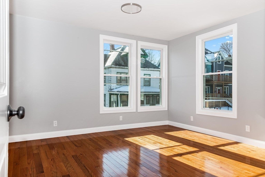 16 Gaston Street, Unit 2F Boston, MA 02121 - Photo 5 of 7 an empty room with wooden floor and windows