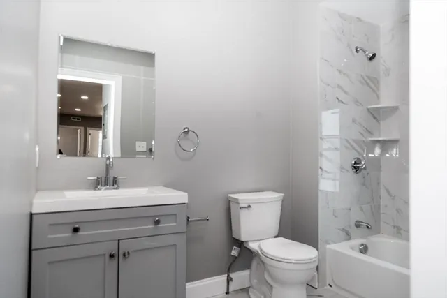 a bathroom with a sink toilet vanity and tub