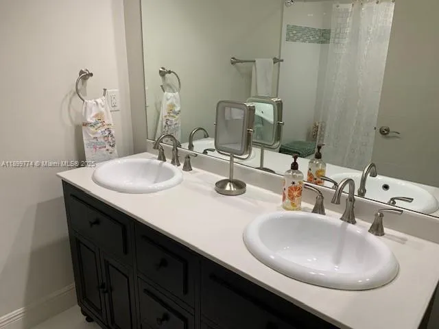 a bathroom with double vanity sinks and a mirror