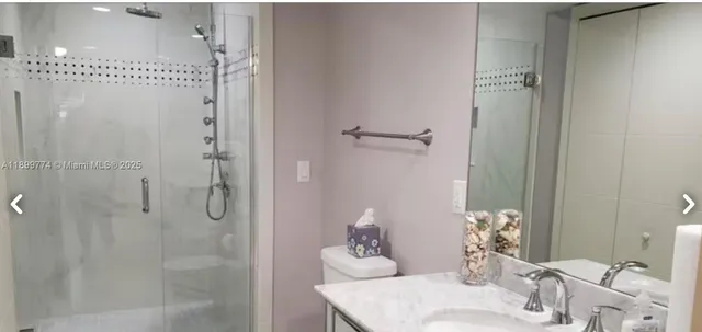 a bathroom with a granite countertop shower sink and toilet