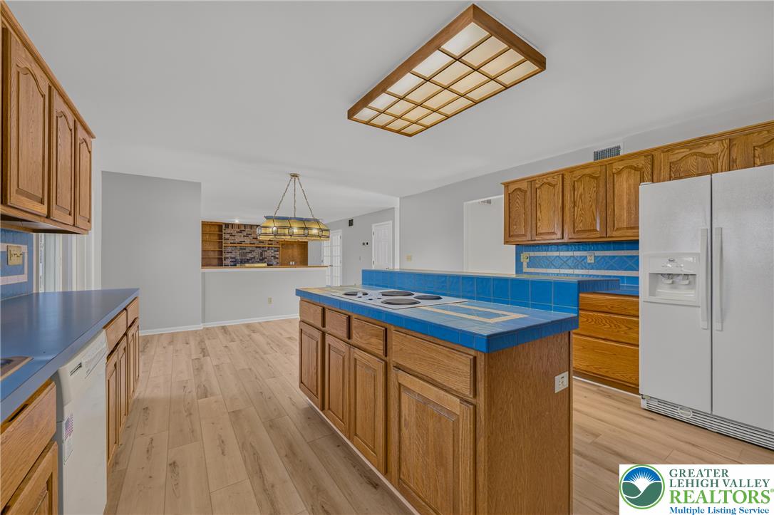 630 Clearfield Road Nazareth, PA 18064 - Photo 34 of 100 Rich wood cabinetry contrasts beautifully with blue tiled countertops in this open kitchen.