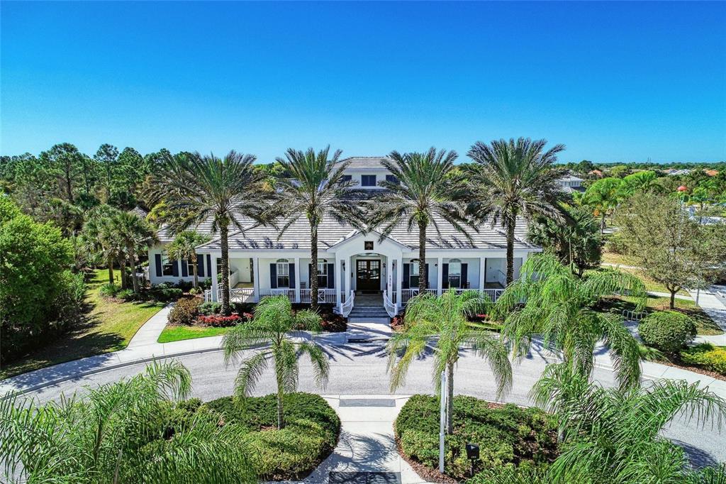 12642 Harney Street Venice, FL 34293 - Photo 56 of 85 a front view of house and yard with swimming pool and trees in the background