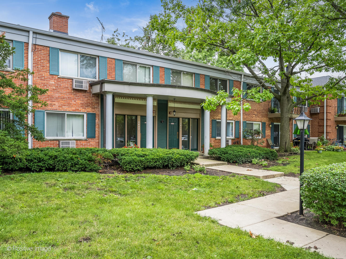 2407 South Goebbert Road, Unit G202 Arlington Heights, IL 60005 - Photo 1 of 17 front view of a brick house with a yard