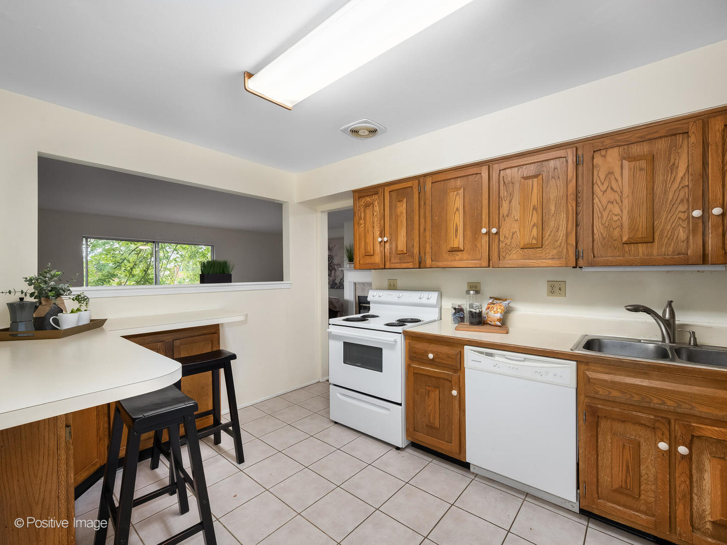 2407 South Goebbert Road, Unit G202 Arlington Heights, IL 60005 - Photo 2 of 17 a kitchen with a stove a sink cabinets and a window