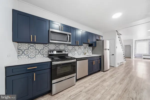 a kitchen with stainless steel appliances granite countertop wooden cabinets a stove top oven a sink and dishwasher
