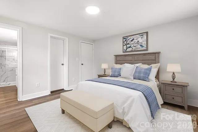 a spacious bedroom with a bed and a night stand