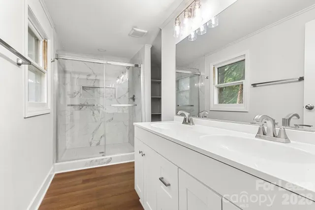 a bathroom with a sink shower and a mirror