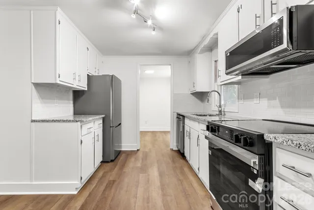 a kitchen with stainless steel appliances a stove a sink and a refrigerator