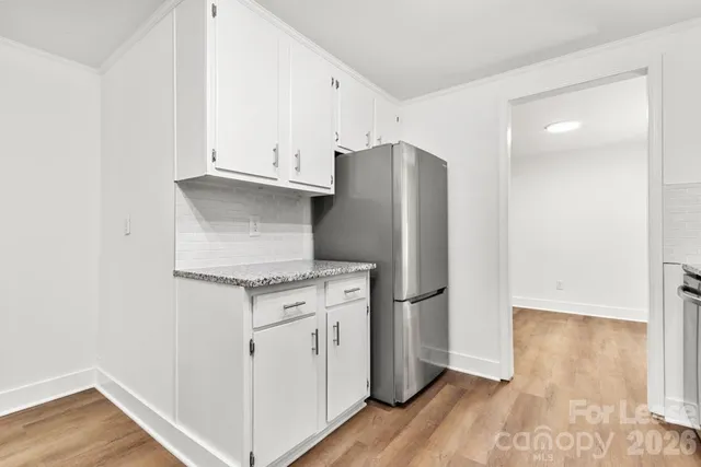 a kitchen with granite countertop a refrigerator and a stove top oven