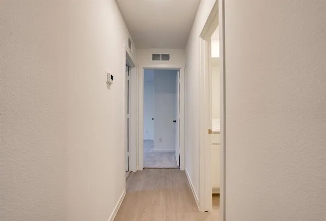 a view of a hallway with wooden floor