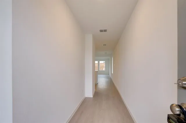 a view of a hallway with wooden floor