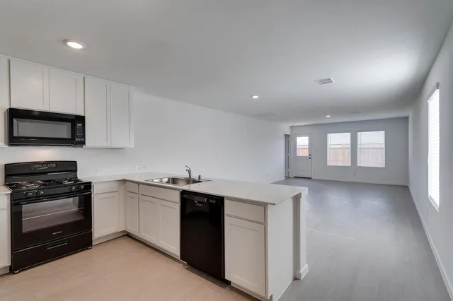 a kitchen with a sink stove and microwave