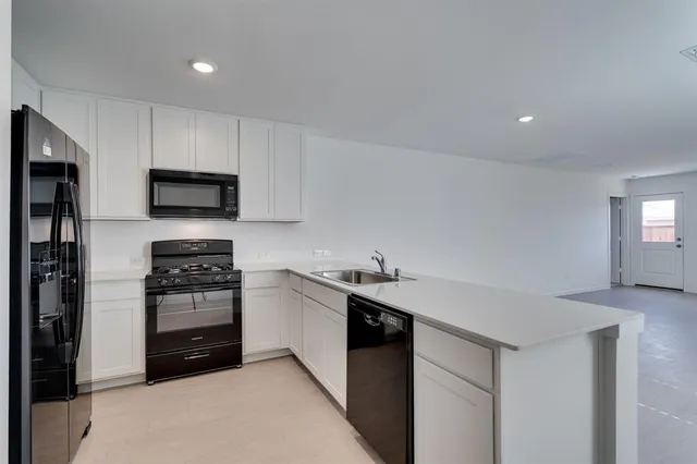 a kitchen with stainless steel appliances granite countertop a stove a sink and a refrigerator