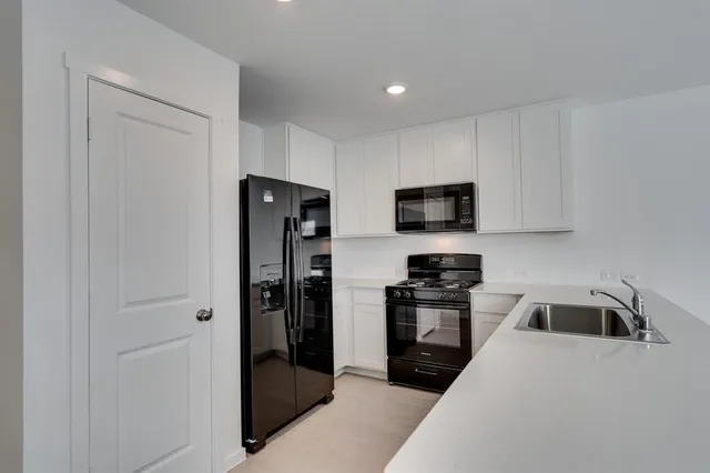 a kitchen with stainless steel appliances granite countertop a refrigerator and a stove top oven