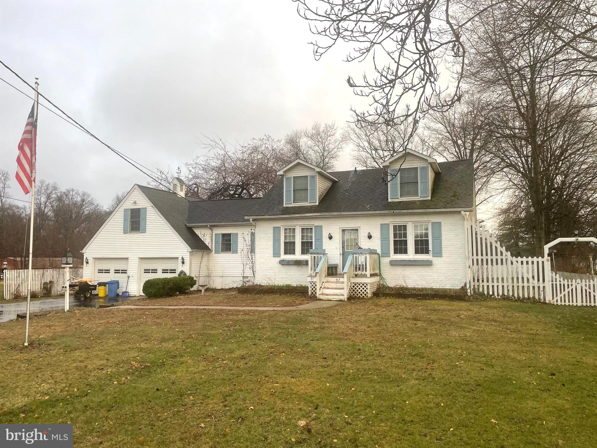 a front view of house with yard and trees around