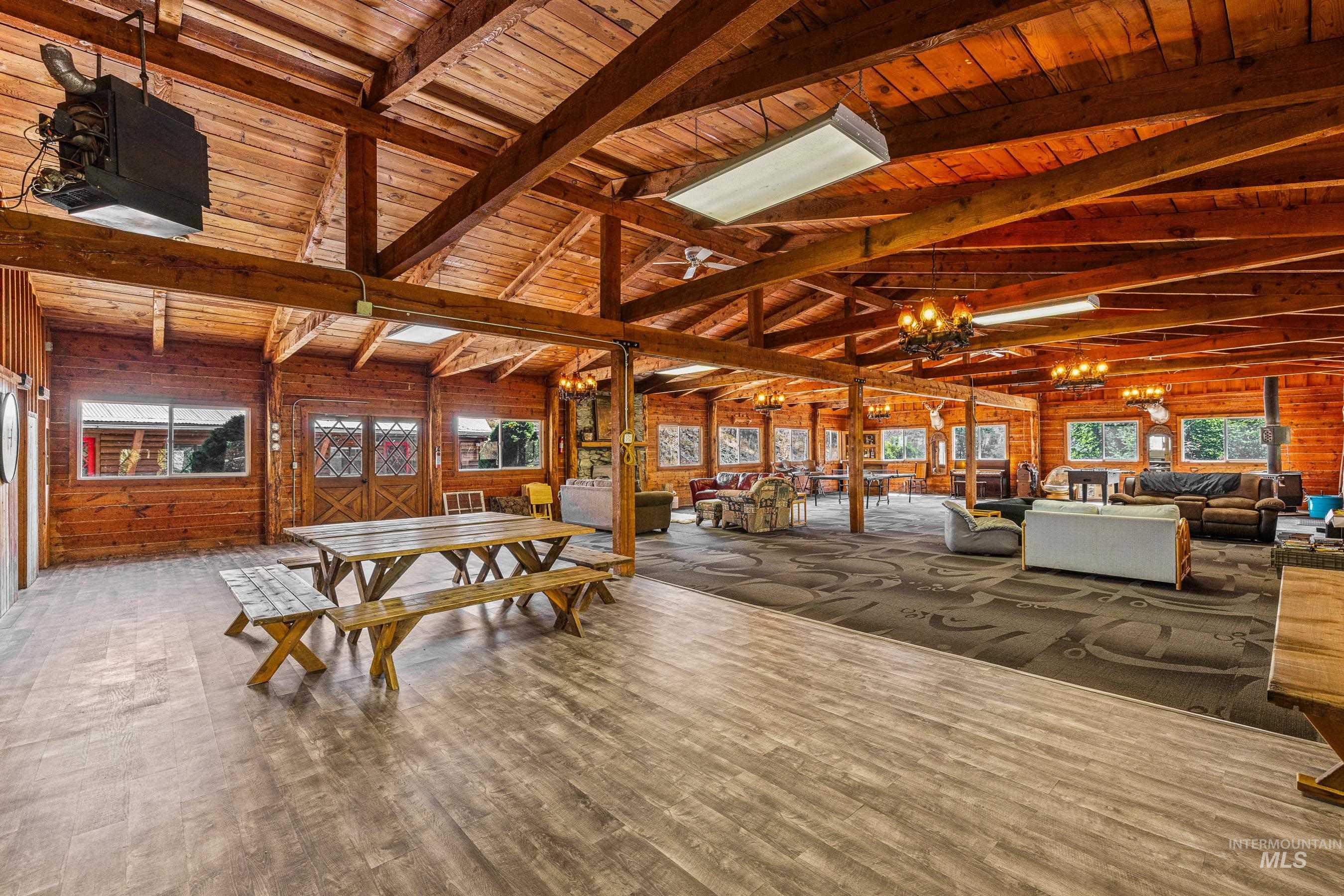 192 East Shingle Creek Road Riggins, ID 83549 - Photo 11 of 50 Dining space with wood walls, a chandelier, wood finished floors, and wooden ceiling