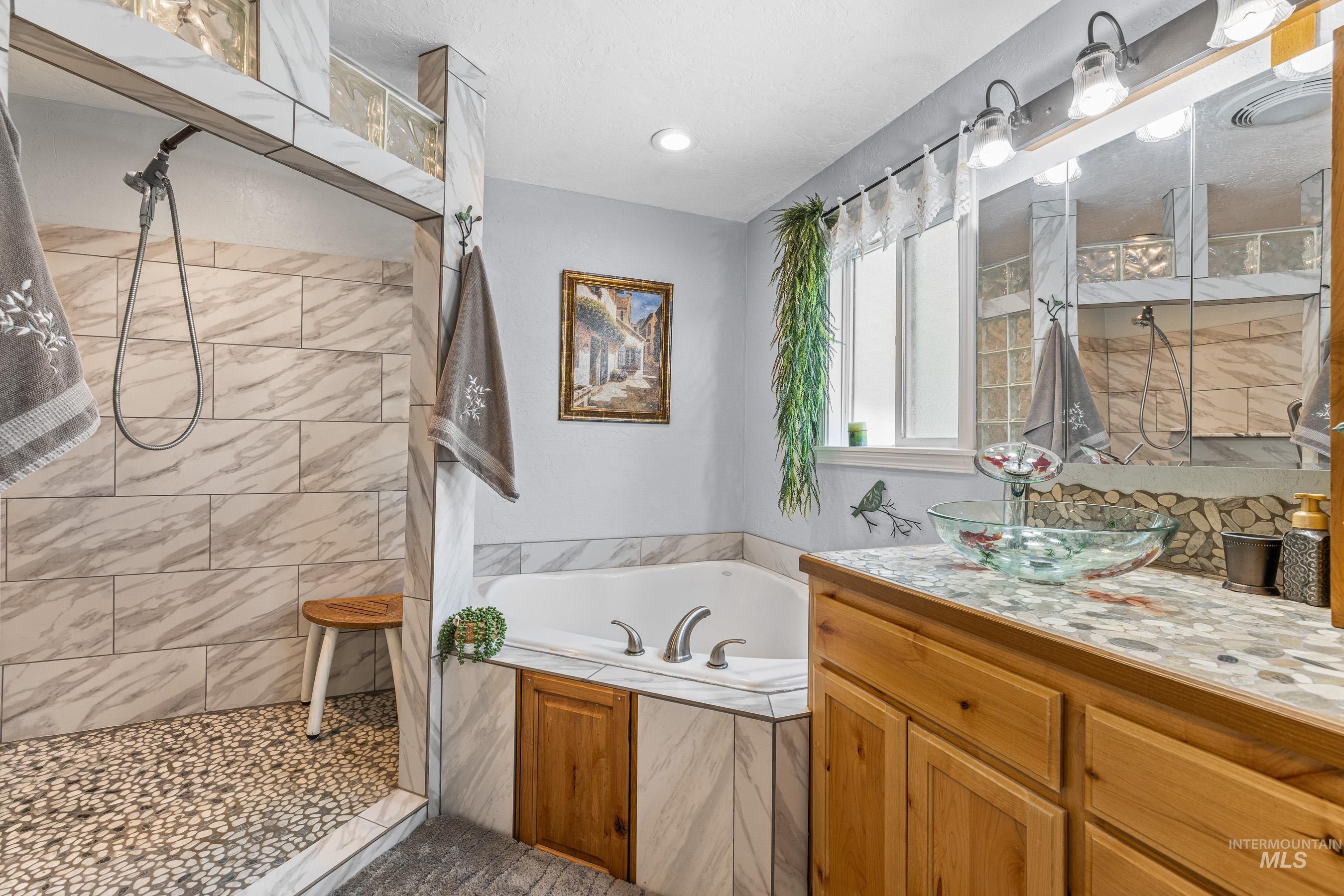 192 East Shingle Creek Road Riggins, ID 83549 - Photo 29 of 50 Bathroom with a tile shower, a garden tub, and vanity