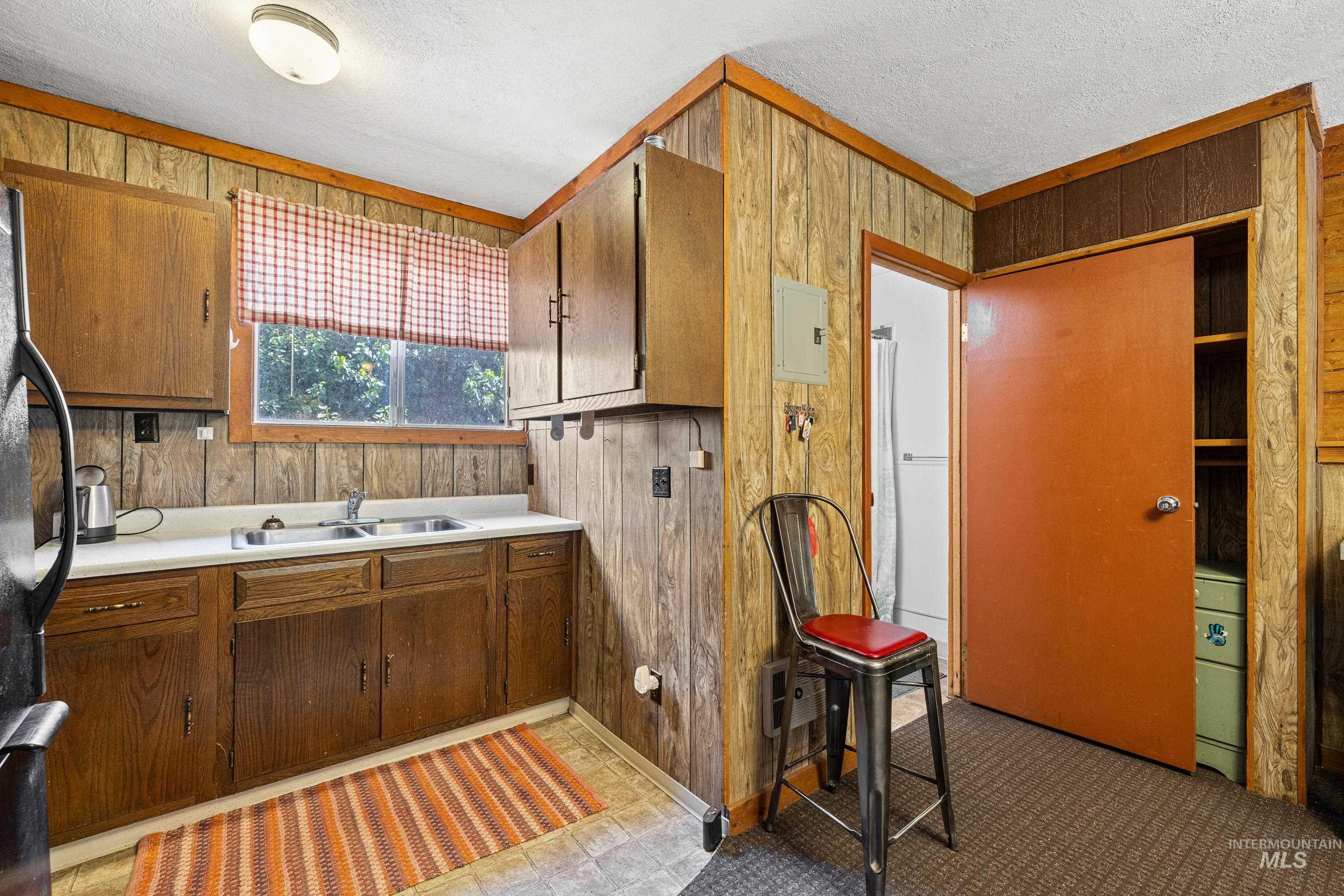 192 East Shingle Creek Road Riggins, ID 83549 - Photo 36 of 50 Bathroom with wooden walls, a textured ceiling, electric panel, and a garden tub