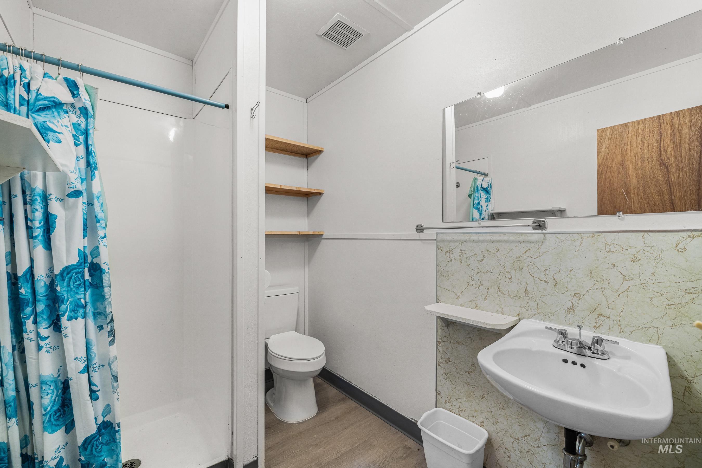 192 East Shingle Creek Road Riggins, ID 83549 - Photo 44 of 50 Bathroom with a stall shower, light wood-style flooring, and backsplash