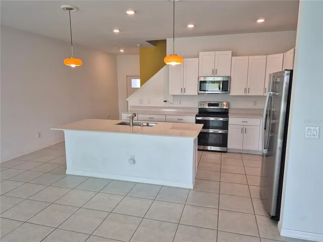 a kitchen with stainless steel appliances a refrigerator sink and microwave