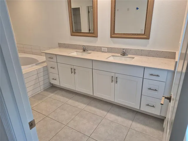 a spacious bathroom with a sink and a mirror