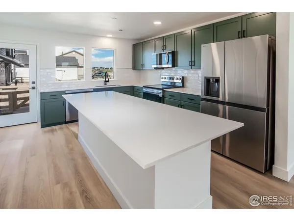 a kitchen with stainless steel appliances a refrigerator sink and stove