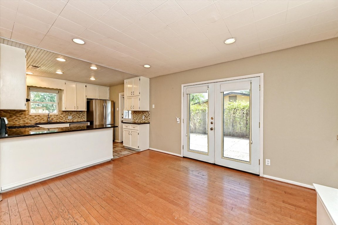 5205 Brookdale Lane Austin, TX 78723 - Photo 5 of 22 a large kitchen with stainless steel appliances granite countertop a refrigerator a sink a stove and a wooden floors