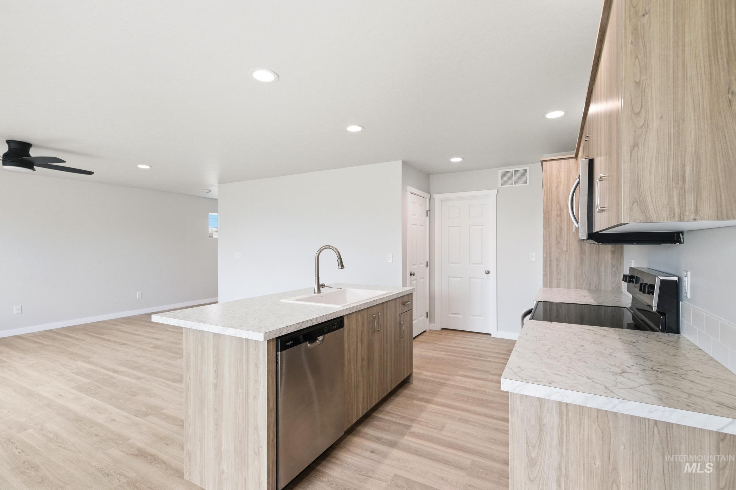 2446 West Fallon Loop Nampa, ID 83651 - Photo 5 of 19 Kitchen featuring an island with sink, light countertops, stainless steel appliances, light wood finished floors, and recessed lighting