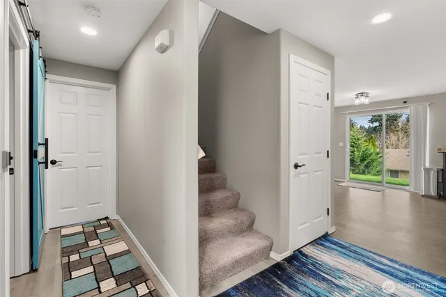 a view of a hallway with wooden floor and cabinet