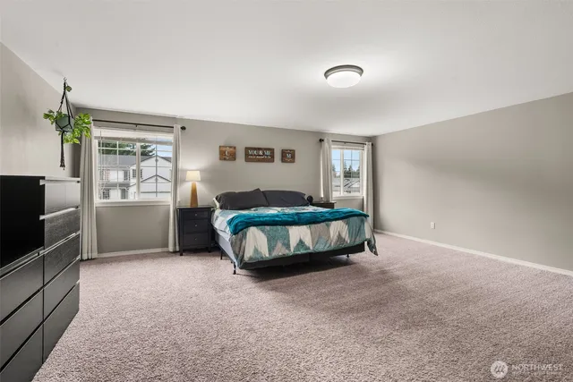 a spacious bedroom with a bed and a flat screen tv