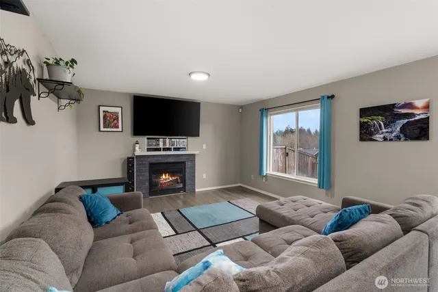 a living room with furniture a flat screen tv and a fireplace