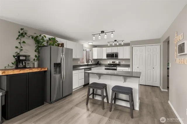 a kitchen with stainless steel appliances a refrigerator and a stove top oven