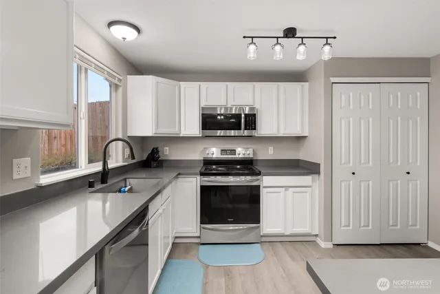 a kitchen with stainless steel appliances granite countertop a stove a sink and a microwave