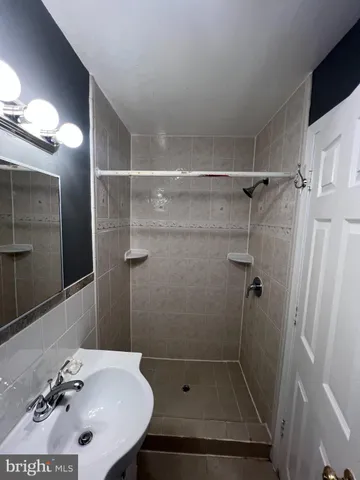 a bathroom with a sink mirror and shower