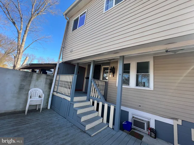 a view of a chair and table in the back yard of the house