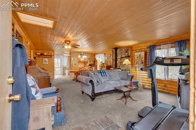 847 Timber Ridge Road Divide, CO 80814 - Photo 4 of 41 Open-concept living space featuring wood paneling, wood-finish ceiling, and skylight