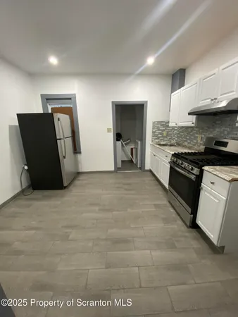 a large kitchen with cabinets and a stove top oven