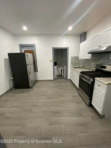 a large kitchen with cabinets and a stove top oven