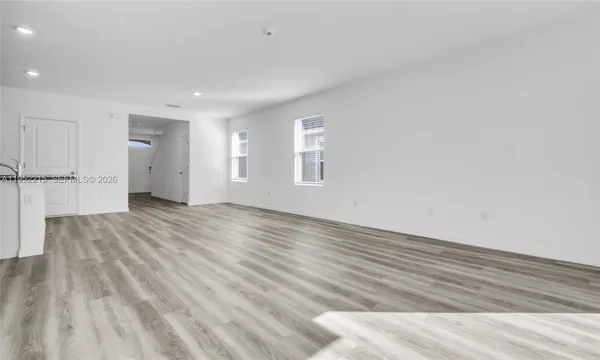 a kitchen with stainless steel appliances granite countertop a refrigerator a sink a stove a microwave and white cabinets