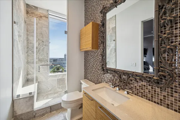 a bathroom with a granite countertop sink toilet and shower