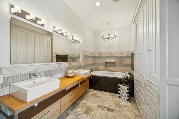 a bathroom with a tub sink and mirror