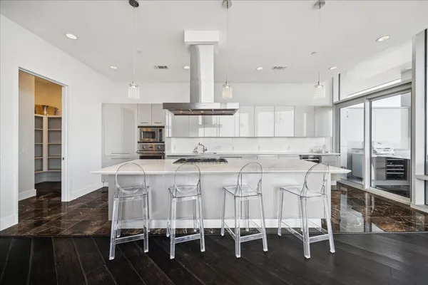 a kitchen with stainless steel appliances kitchen island granite countertop a table chairs sink and cabinets