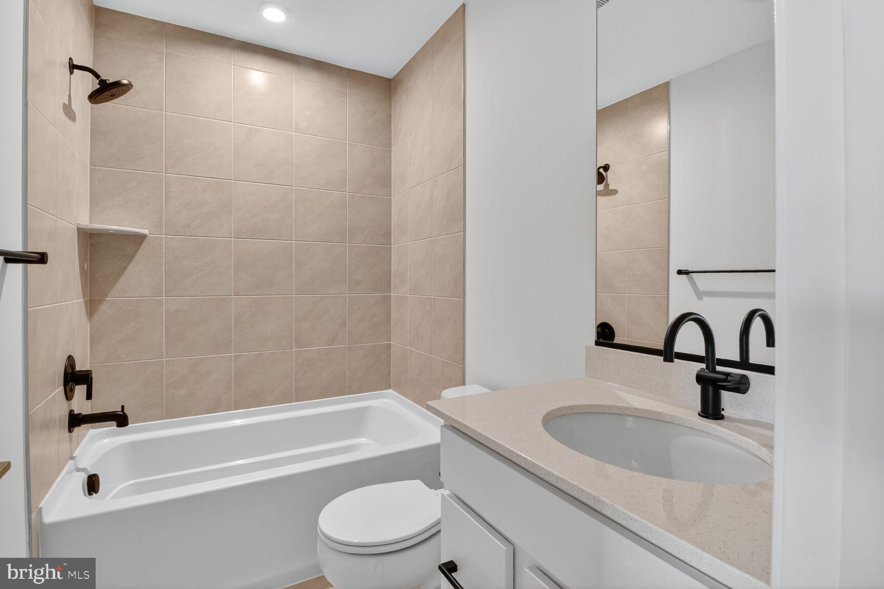 1815 John Stricker Avenue Baltimore, MD 21222 - Photo 13 of 46 a bathroom with a granite countertop bathtub shower sink vanity and toilet