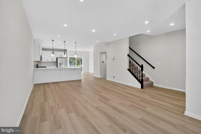 a view of a kitchen with wooden floor and electronic appliances