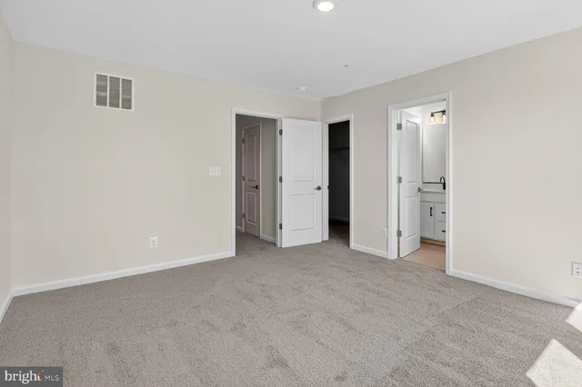 an empty room with closet and windows