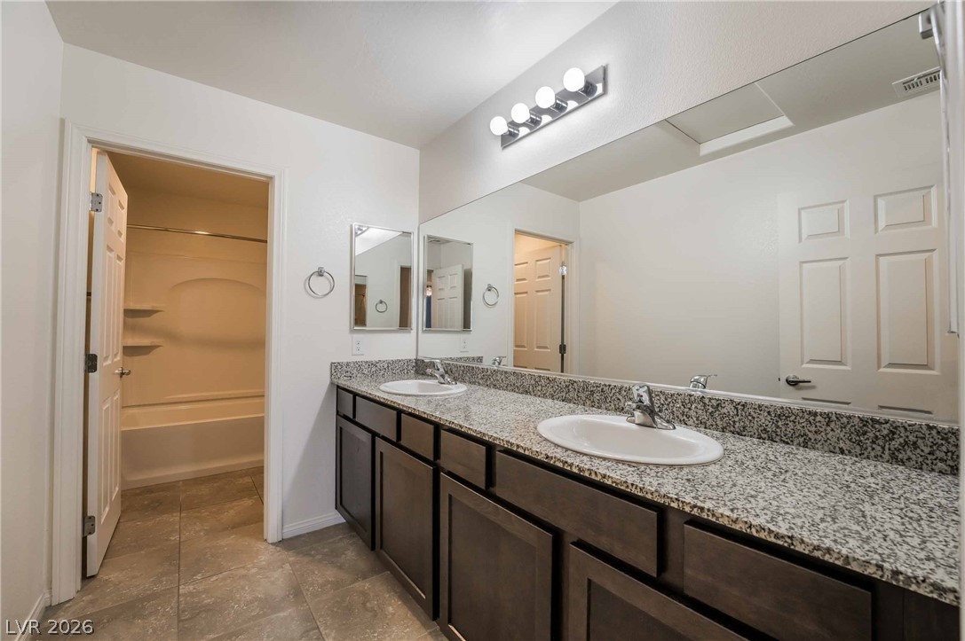 55 Canopus Ridge Way Las Vegas, NV 89183 - Photo 18 of 26 Double vanities with granite counters provide ample space in this well-appointed primary bathroom.