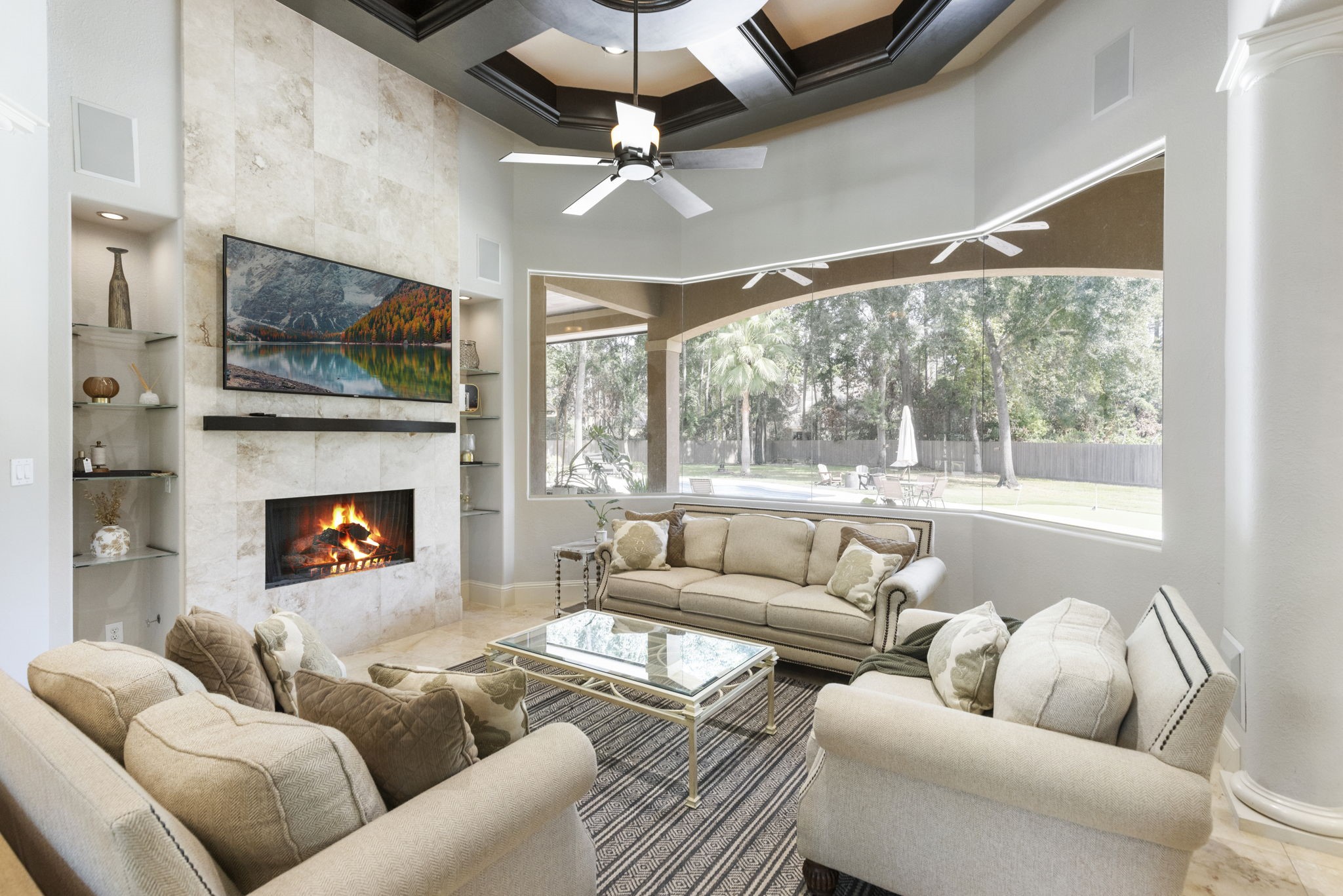 4103 Tee Tree Court Spring, TX 77386 - Photo 6 of 37 Spacious Family Room with a coffered beam ceiling, travertine floors, and a floor-to-ceiling travertine fireplace flanked by built-in shelving.