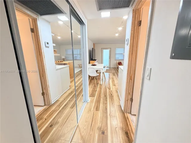 a view of a hallway with wooden floor and staircase