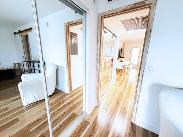 a view of a hallway with wooden floor and furniture