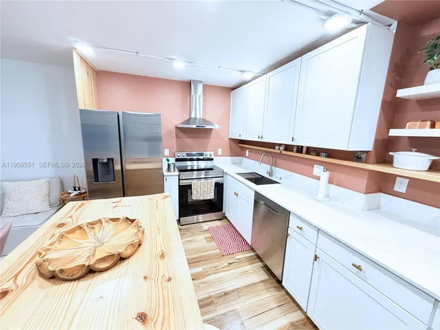 a kitchen with stainless steel appliances kitchen island granite countertop a sink stove and refrigerator